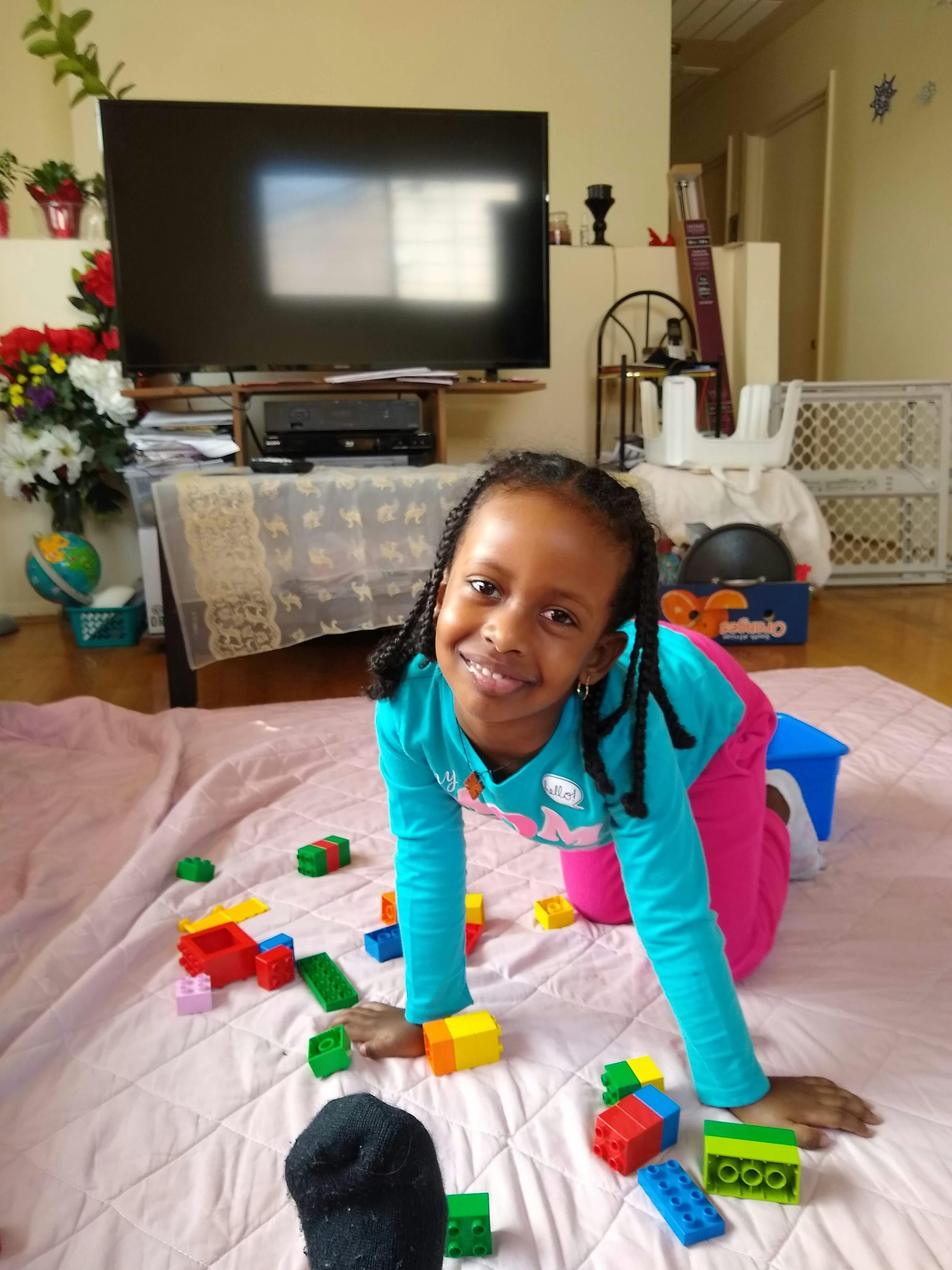 Child on hands and knees on a blanket with building blocks
