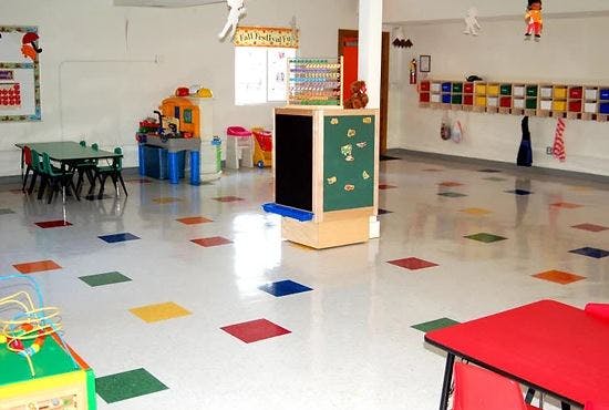 Empty classroom with colorful floor tiles and small tables