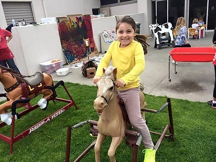 Child riding a toy horse