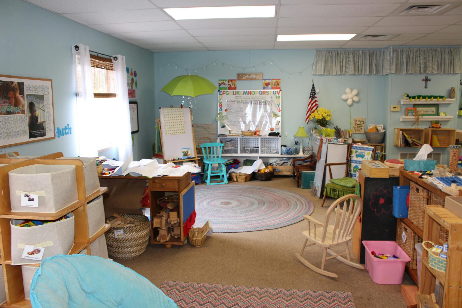 Classroom with light blue walls, whiteboards, and various learning materials
