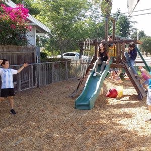 Children playing on a slide and playground equipment
