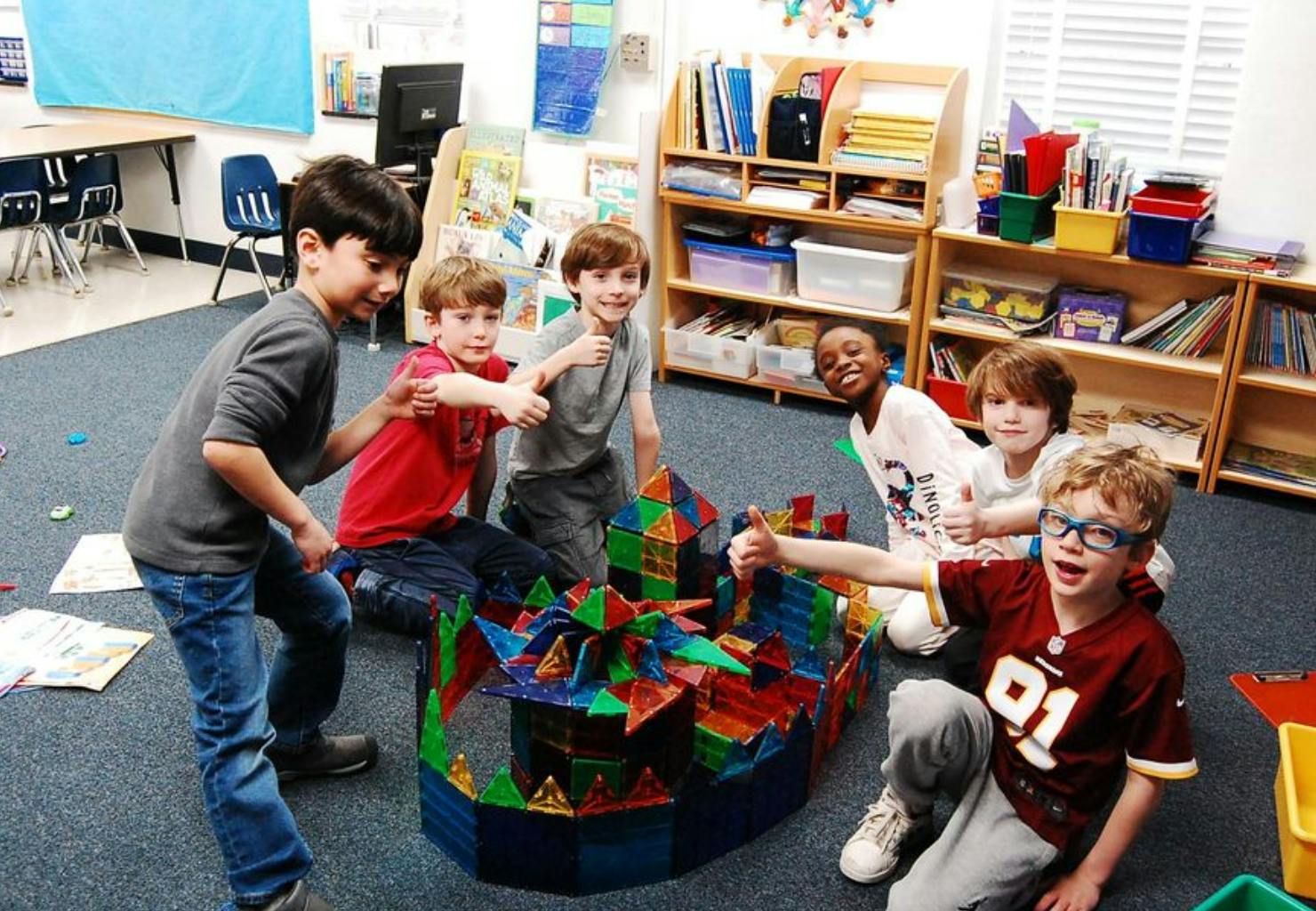 Children playing with colorful magnetic building blocks in a classroom