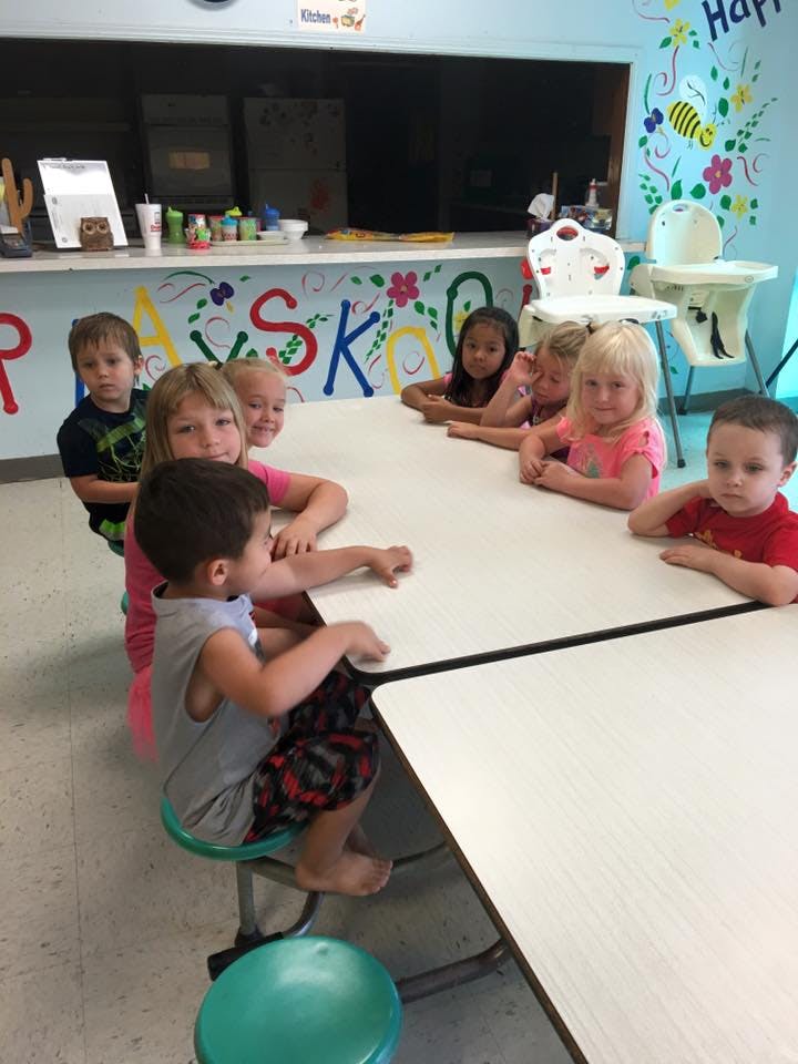 Children sitting at a table in a classroom