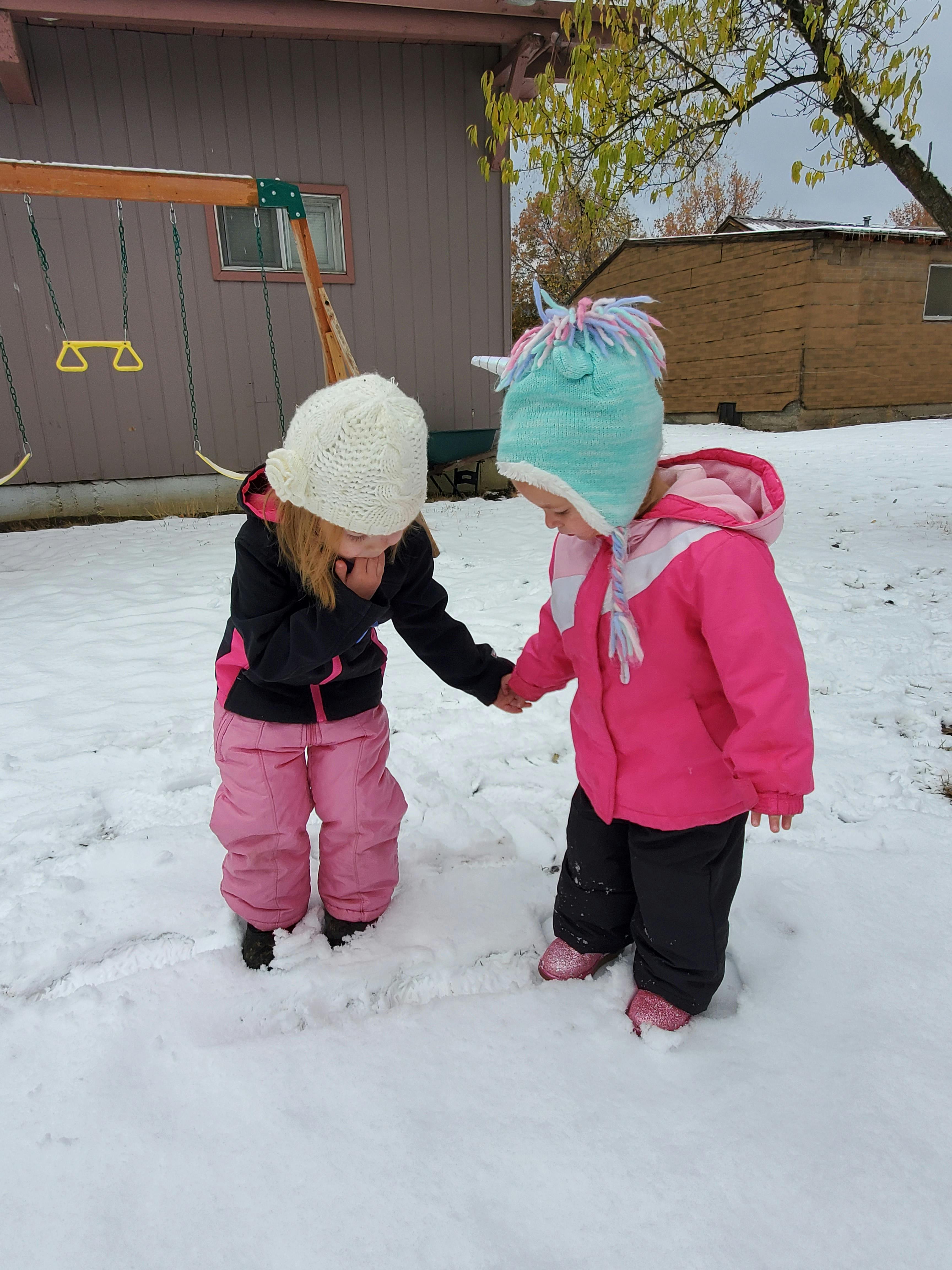 Two children holding hands in the snow