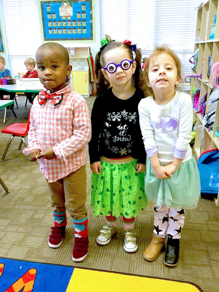 Three children standing in a classroom