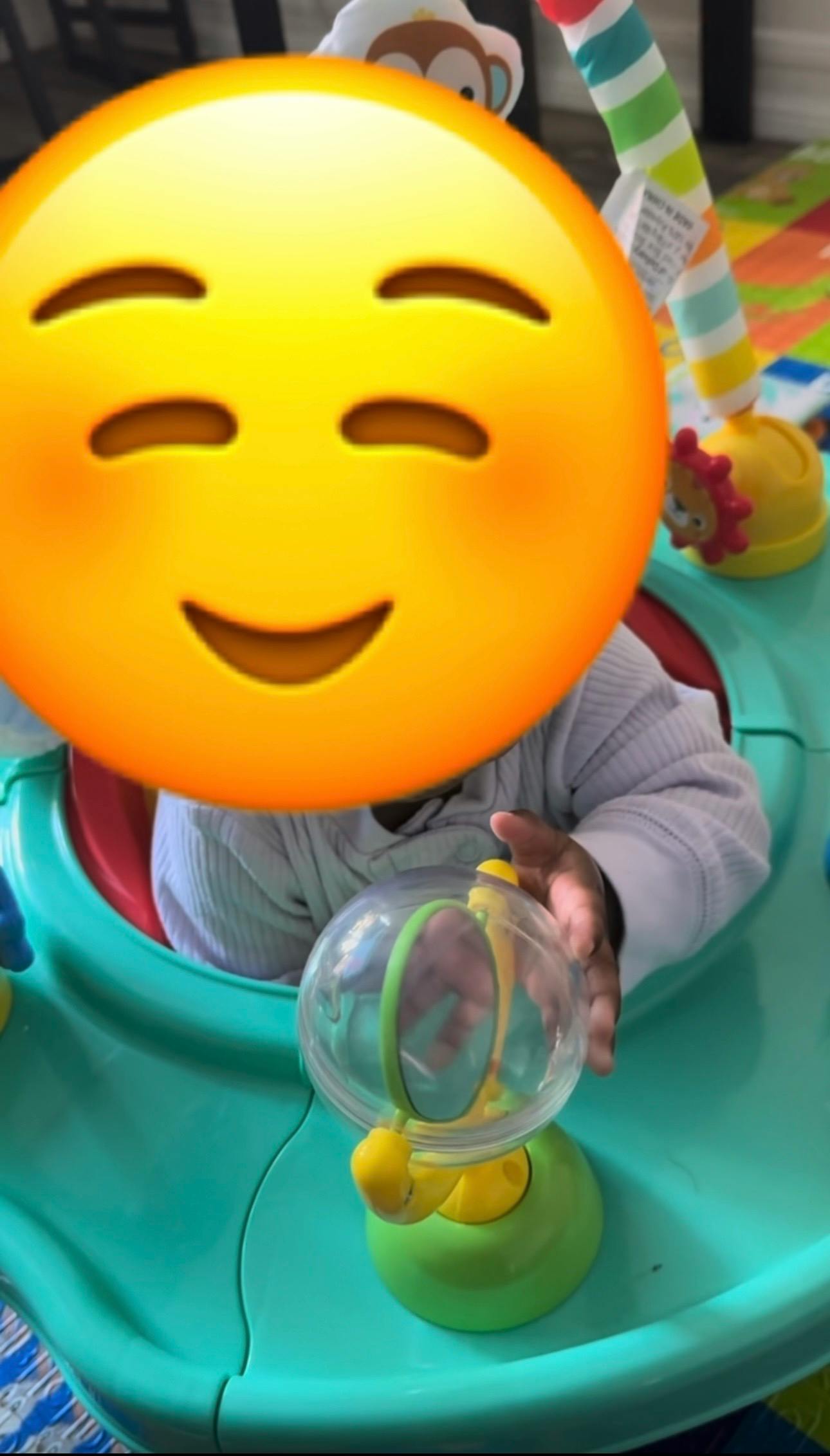 Child sitting in an activity center playing with a toy