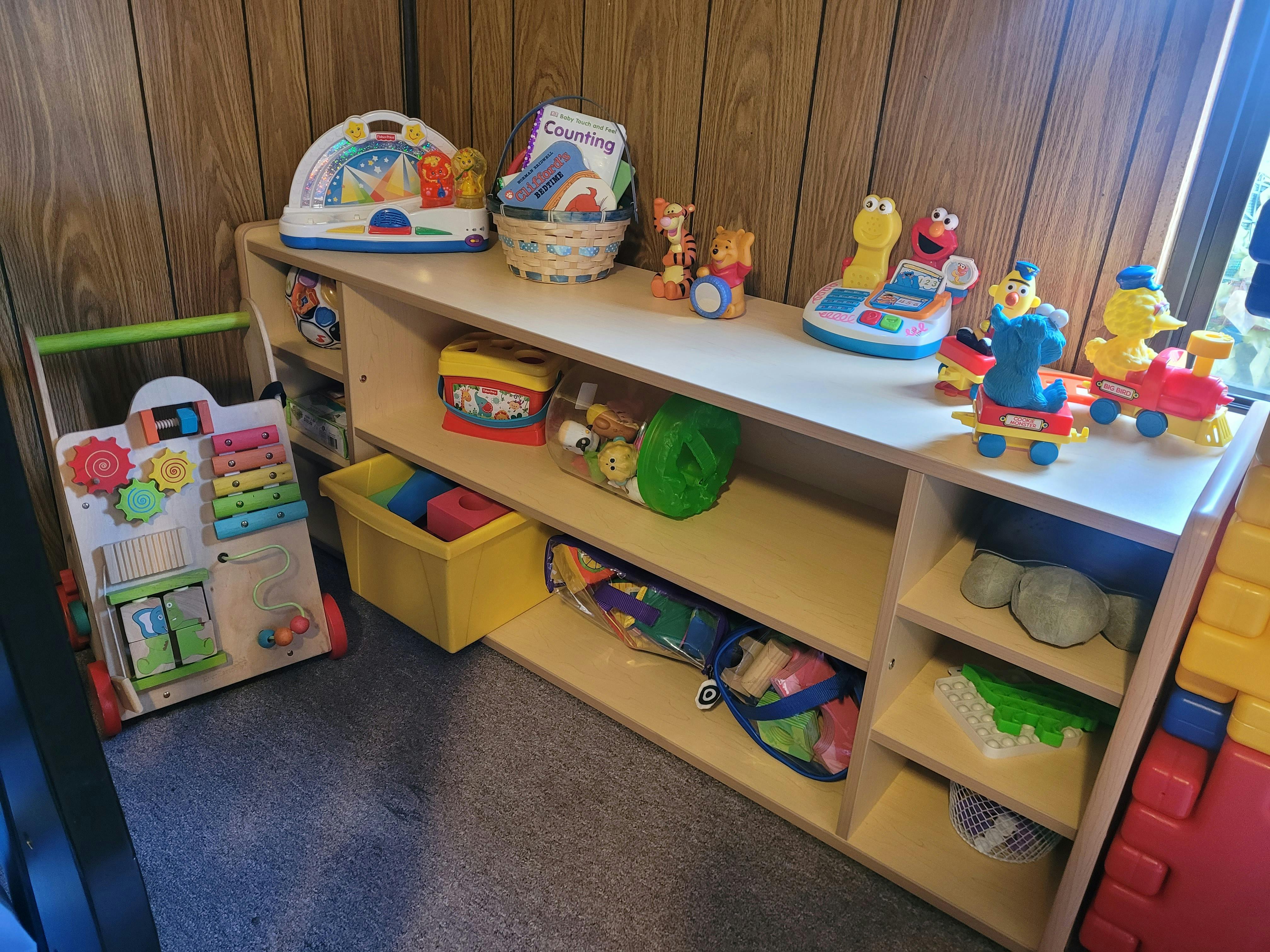 Shelves filled with various toys and a child's walker