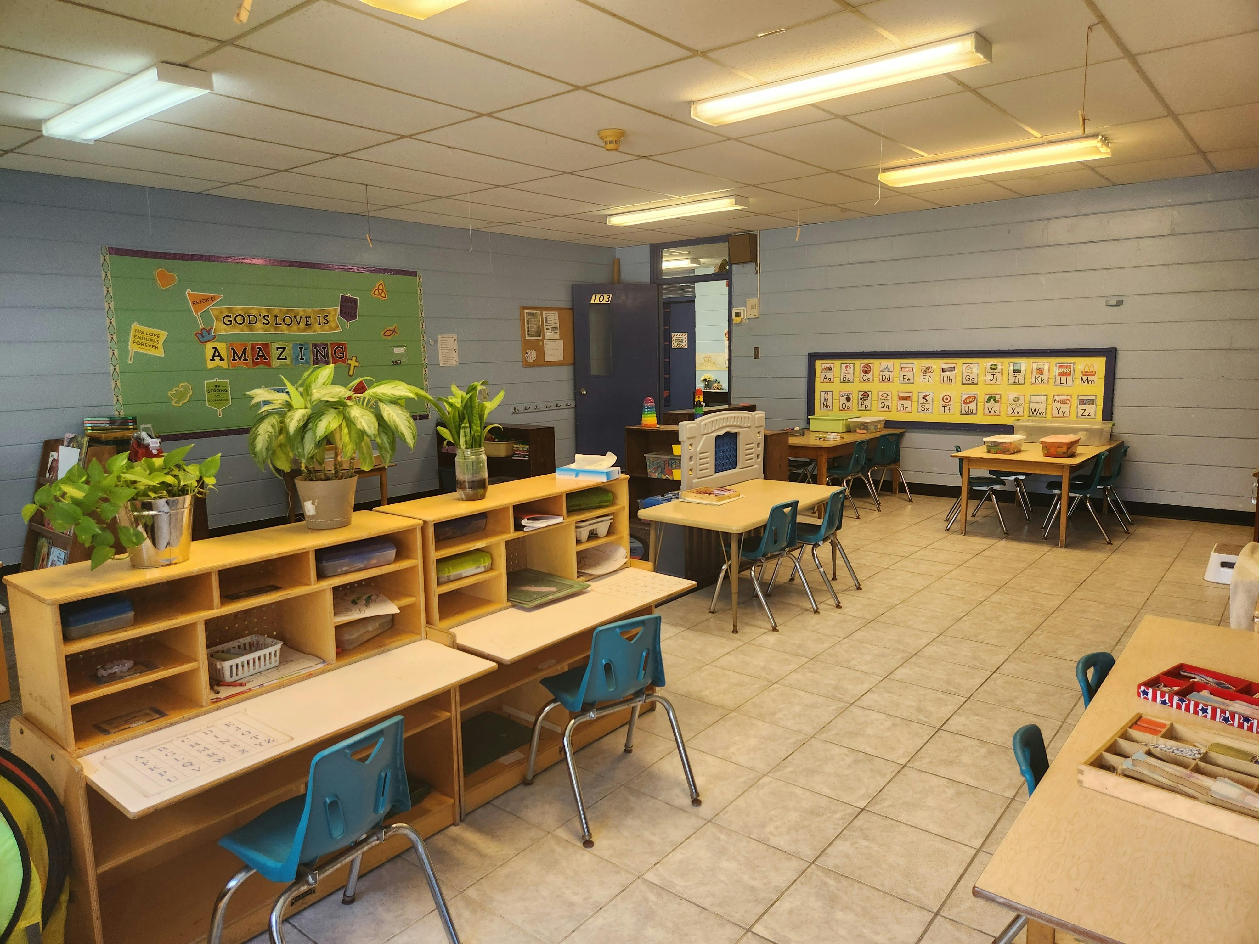 Empty classroom with desks, chairs, and plants