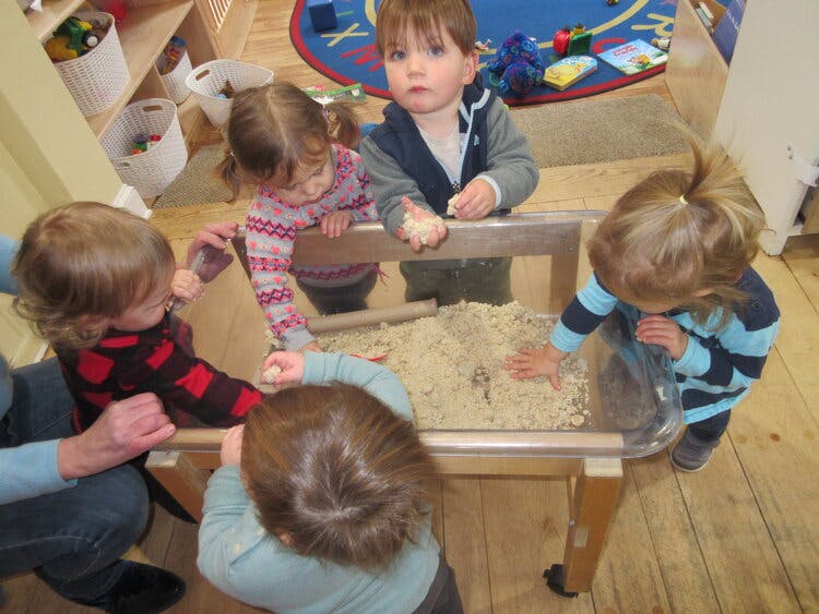 Children playing with sand in a sensory table