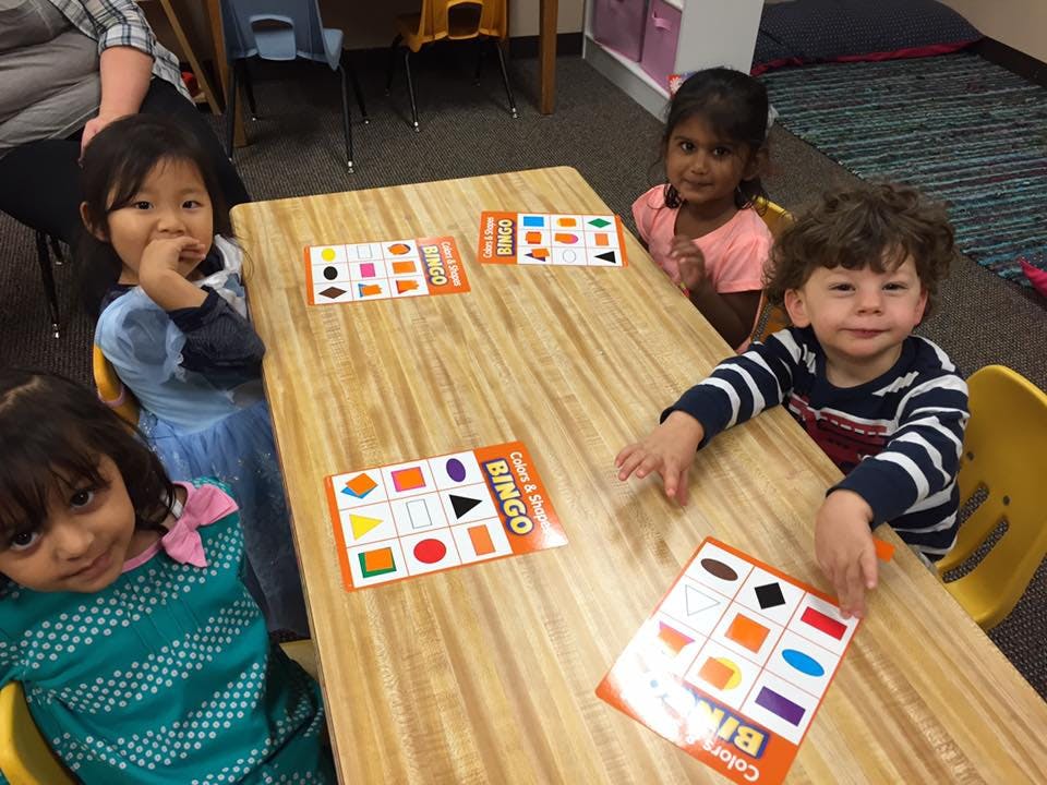 Children playing bingo at a table
