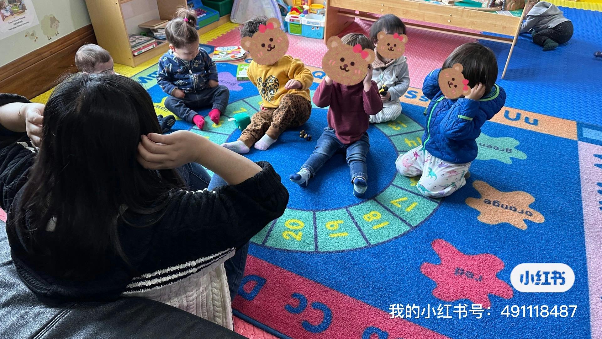Person sitting on floor with children in a circle