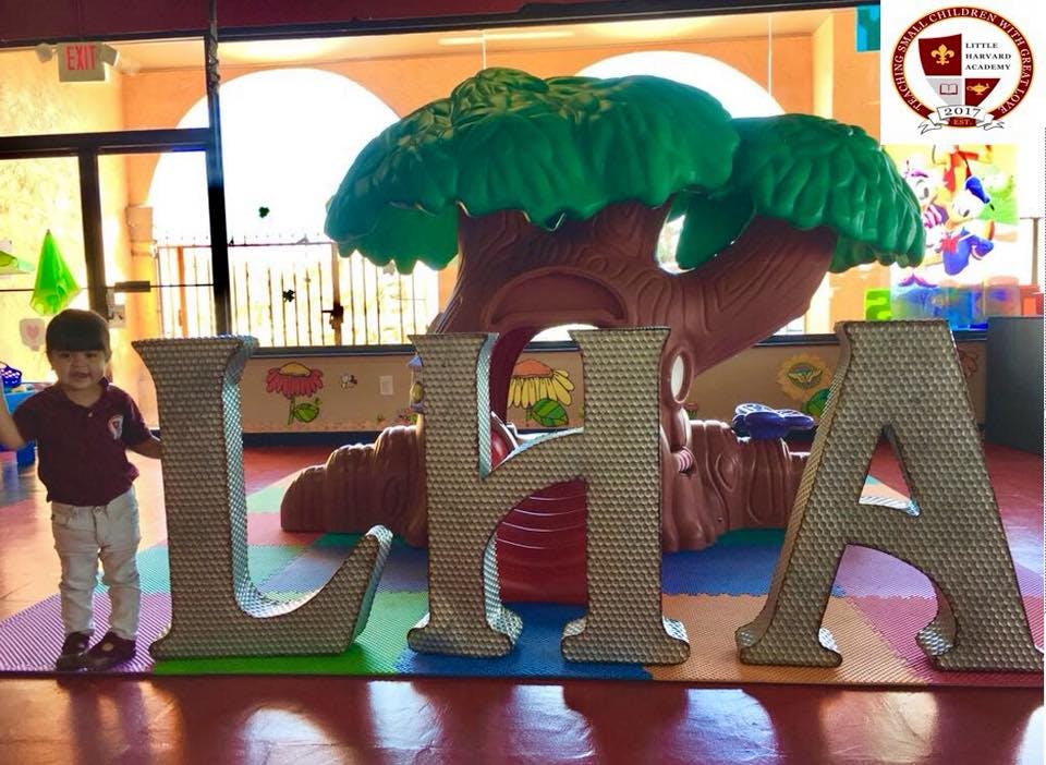 Child standing next to large letters L, H, A in a play area