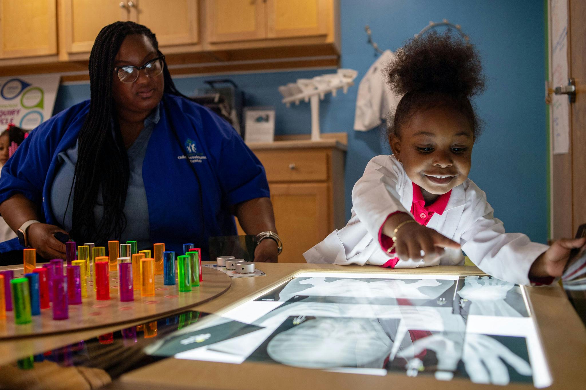 Person and child looking at x-rays on a light table