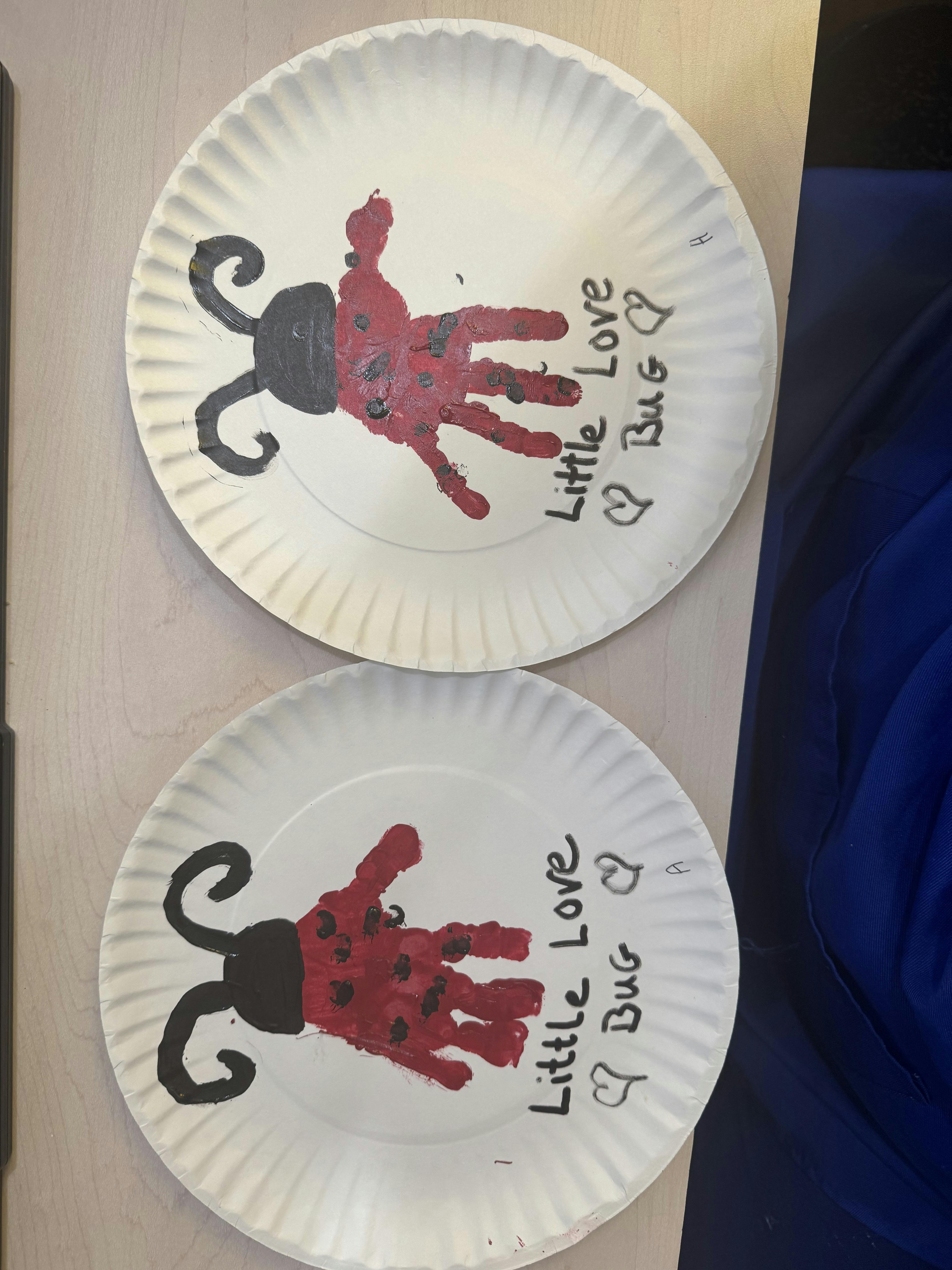 Two paper plates with handprint ladybug crafts and text Little Love Bug