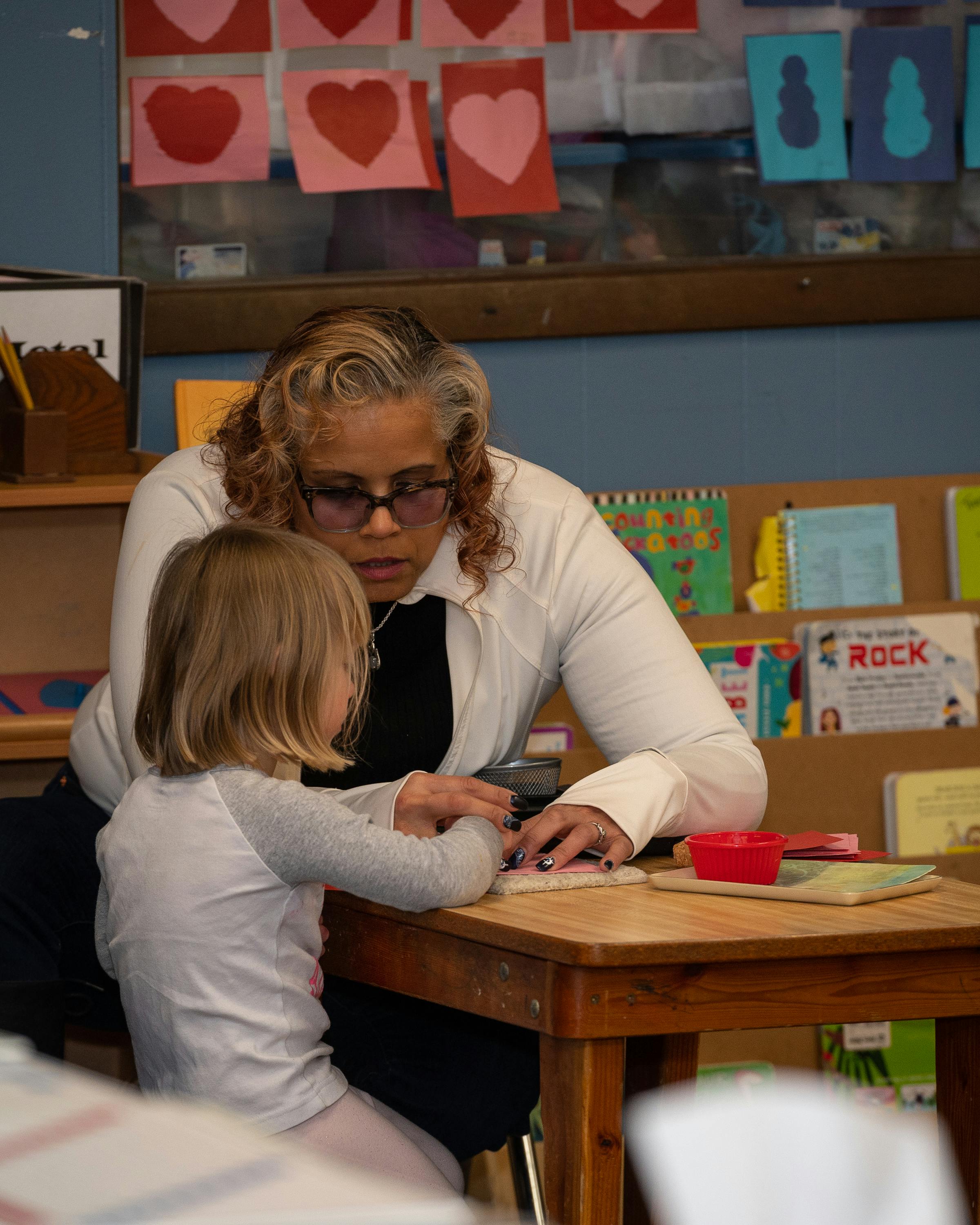 Adult and child at a table in a classroom