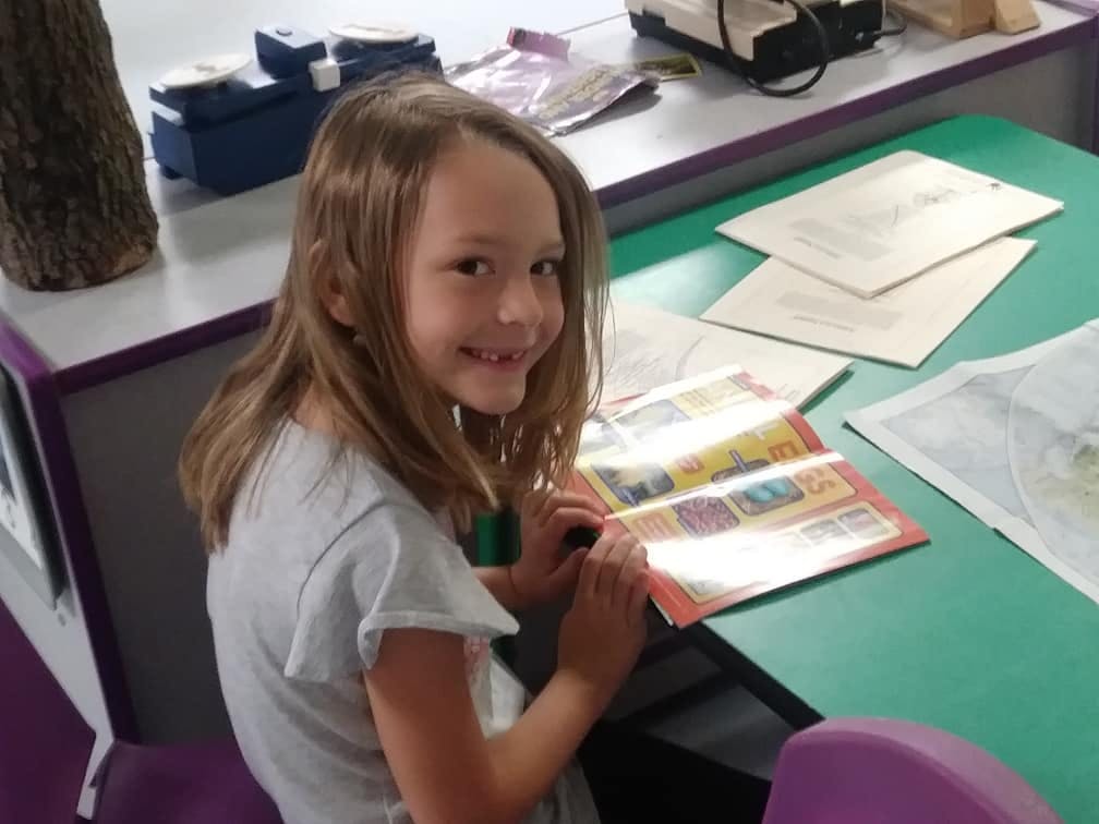 Child sitting at a desk with an open book
