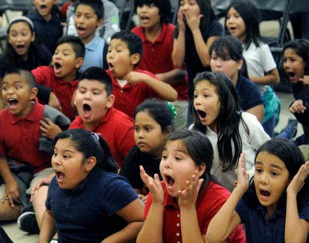 Group of children with mouths open, looking surprised