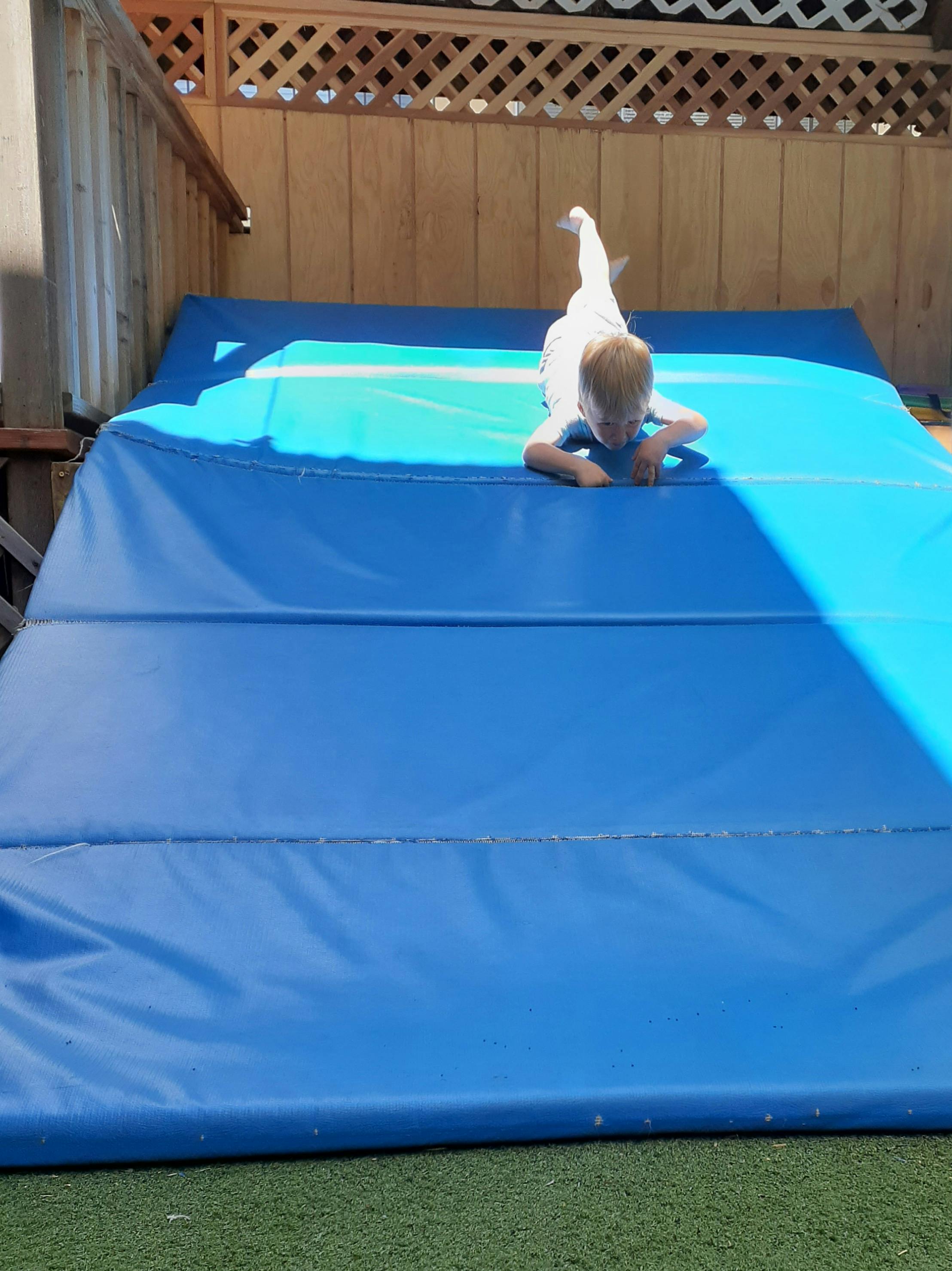 Child lying on stomach on a blue mat