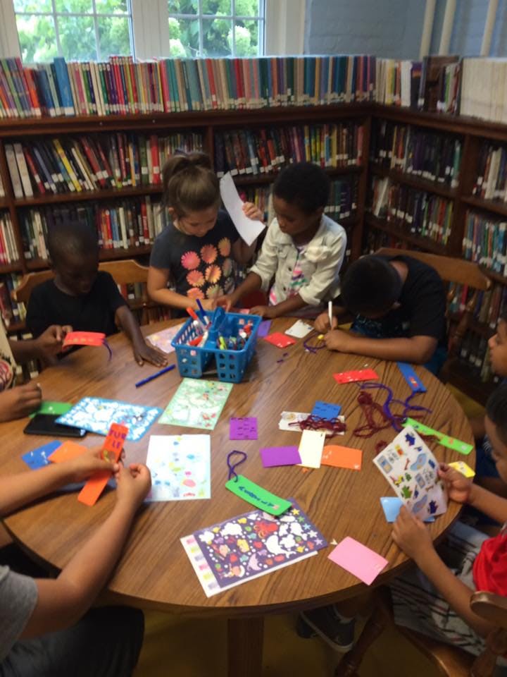 Children doing crafts at a table in a library