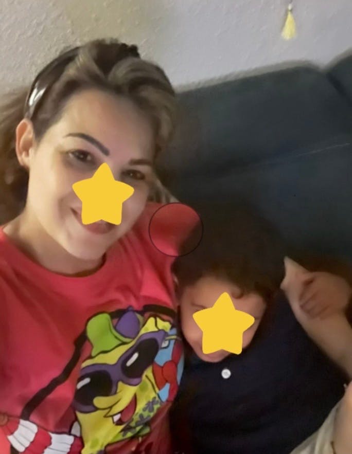 Person in a red shirt with a child wearing a headband with a child