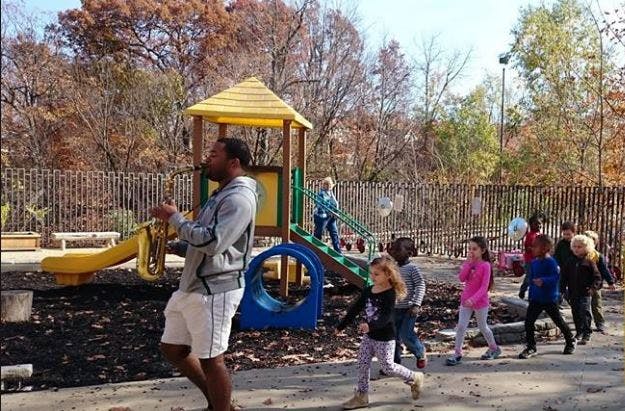 Adult and children on a playground with play structure