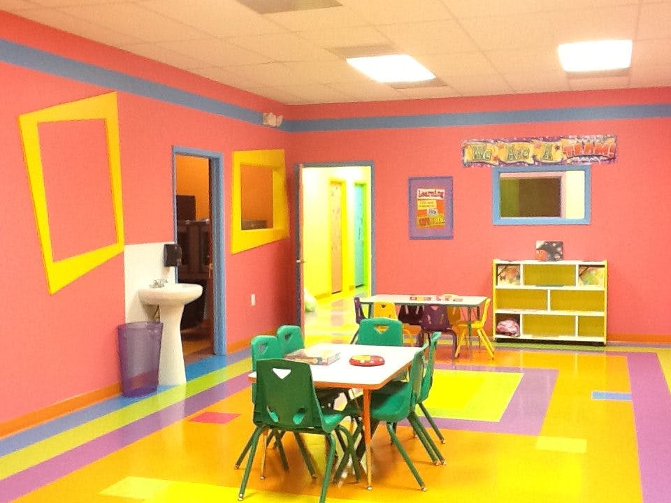 Empty colorful classroom with small tables and chairs