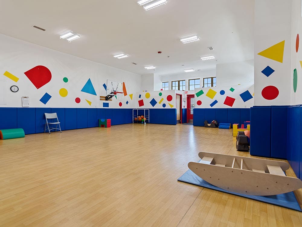Indoor playroom with colorful geometric shapes on walls and play equipment