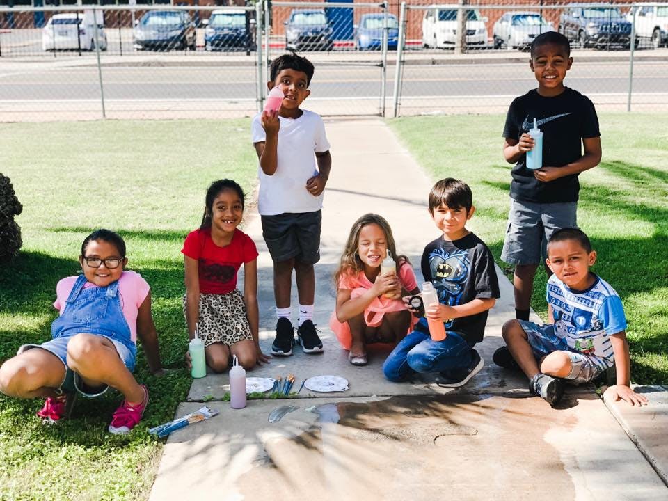 Group of children playing outdoors with bottles and plates