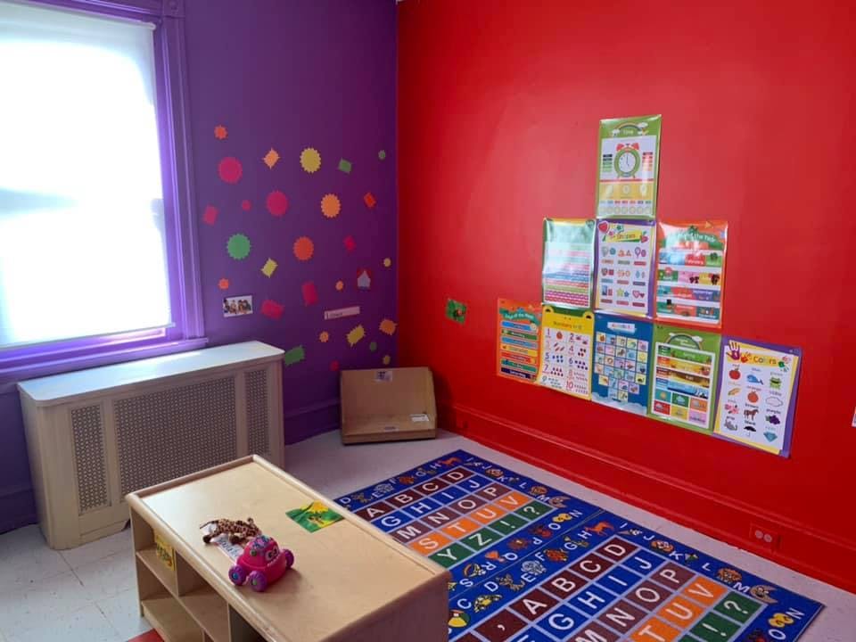 Classroom with alphabet rug, posters on wall, and window