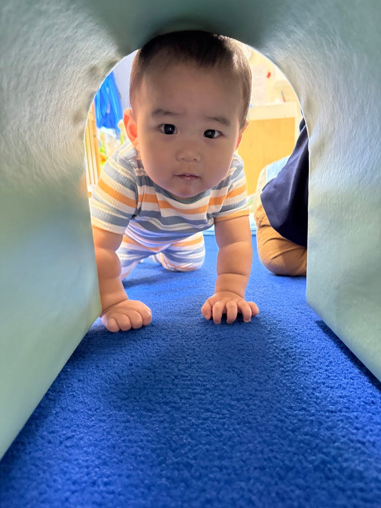 Child crawling out of a soft play tunnel
