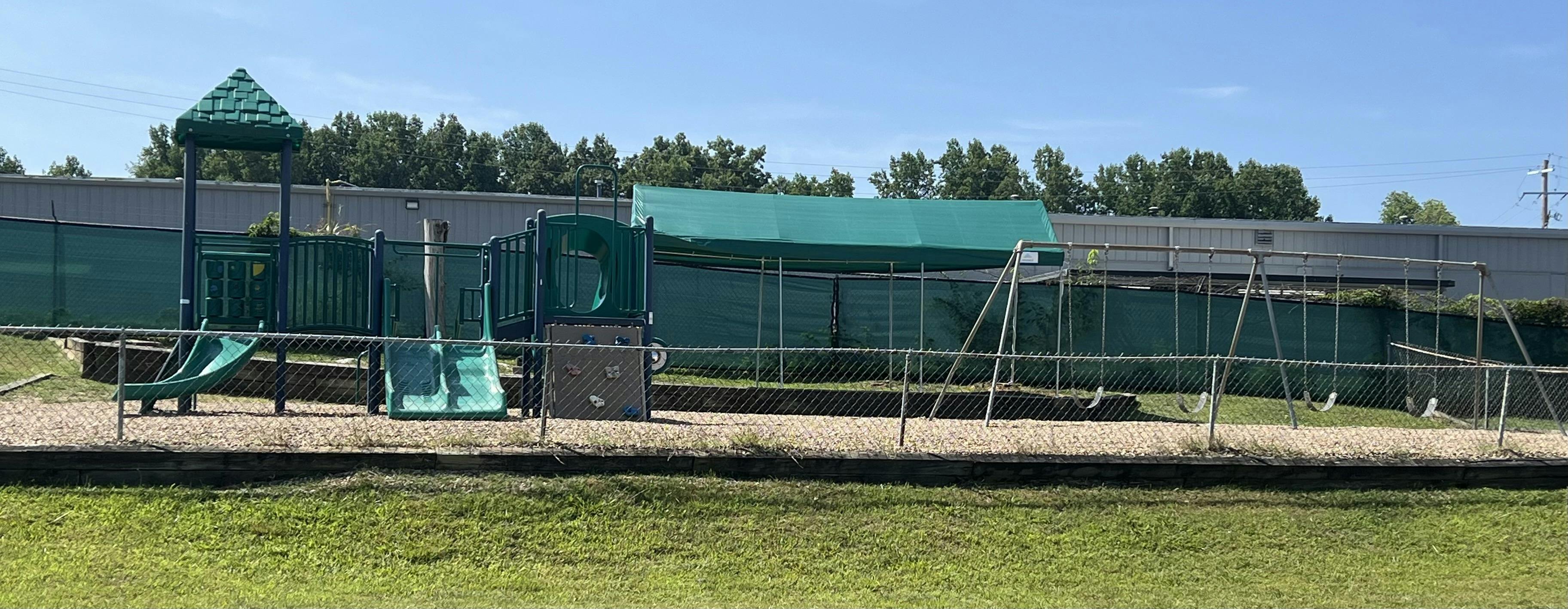 Playground with green slides and swings