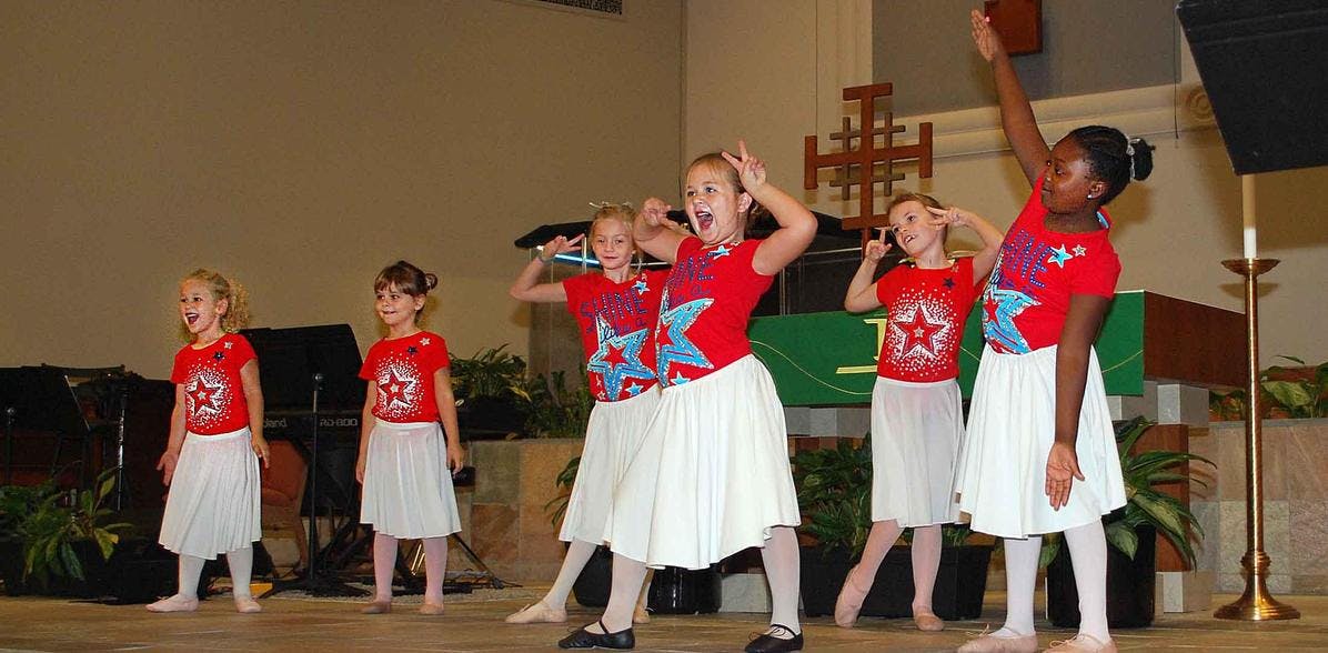Children performing a dance routine on a stage
