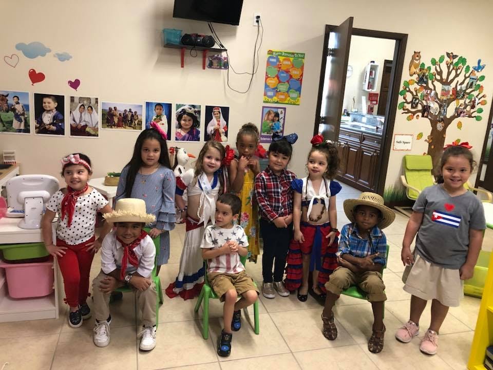 Group of children in costumes standing and sitting in a room