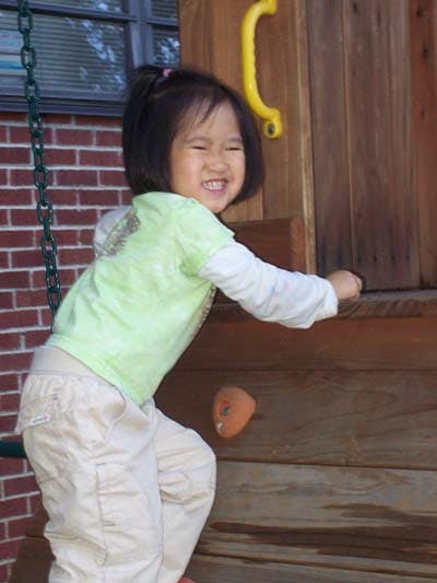 Child climbing on a wooden play structure
