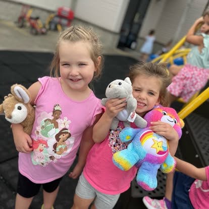Two children holding stuffed animals