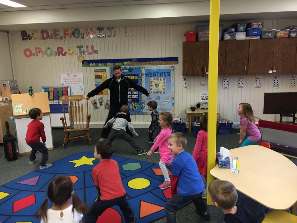 Adult and children in a classroom doing an activity