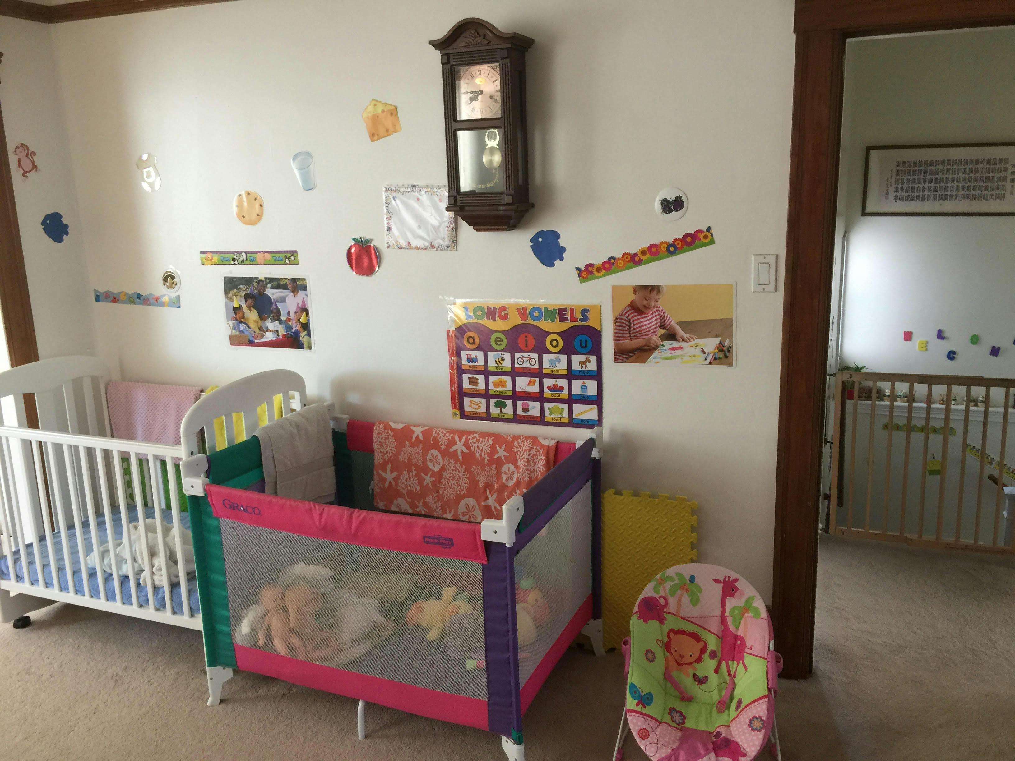 Two cribs in a room with wall decorations