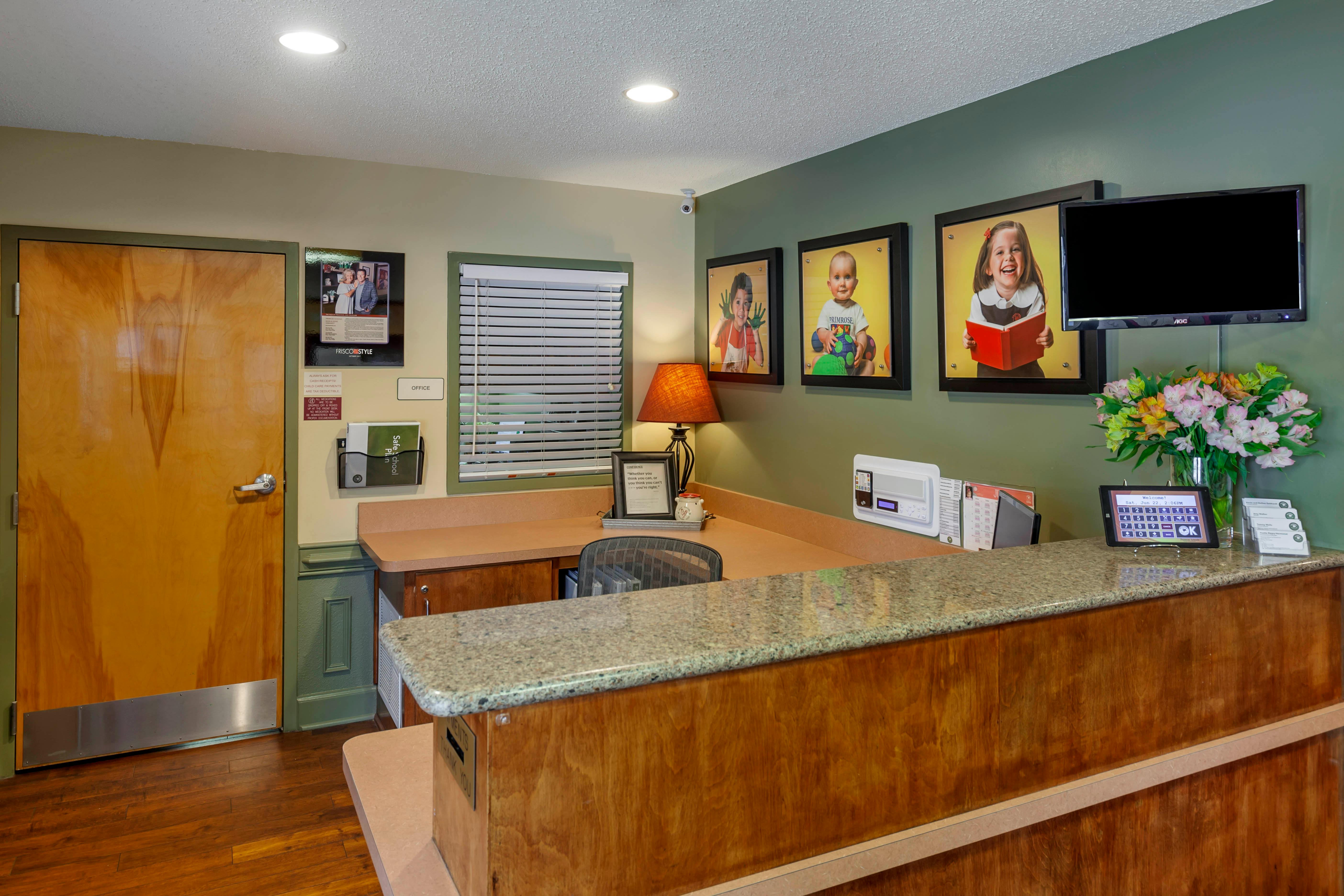 An empty reception desk with a textured granite top and a wooden base