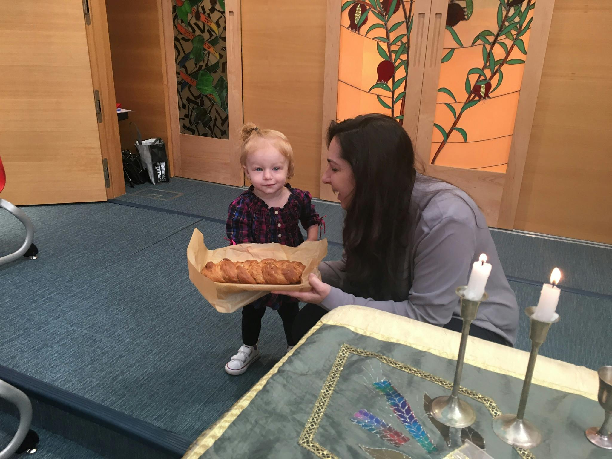 Person and child holding a loaf of bread