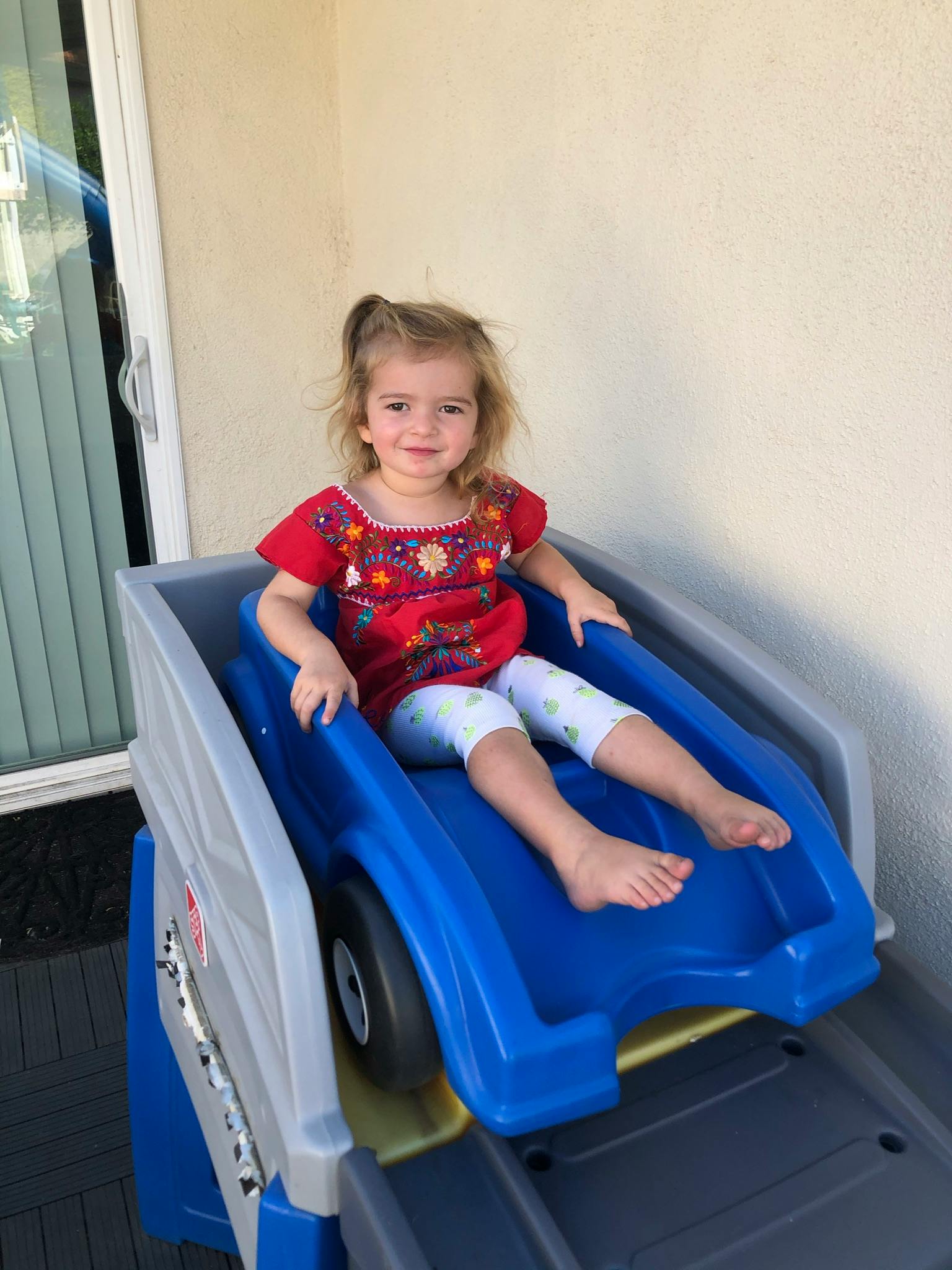 Child sitting on a blue and gray toy slide
