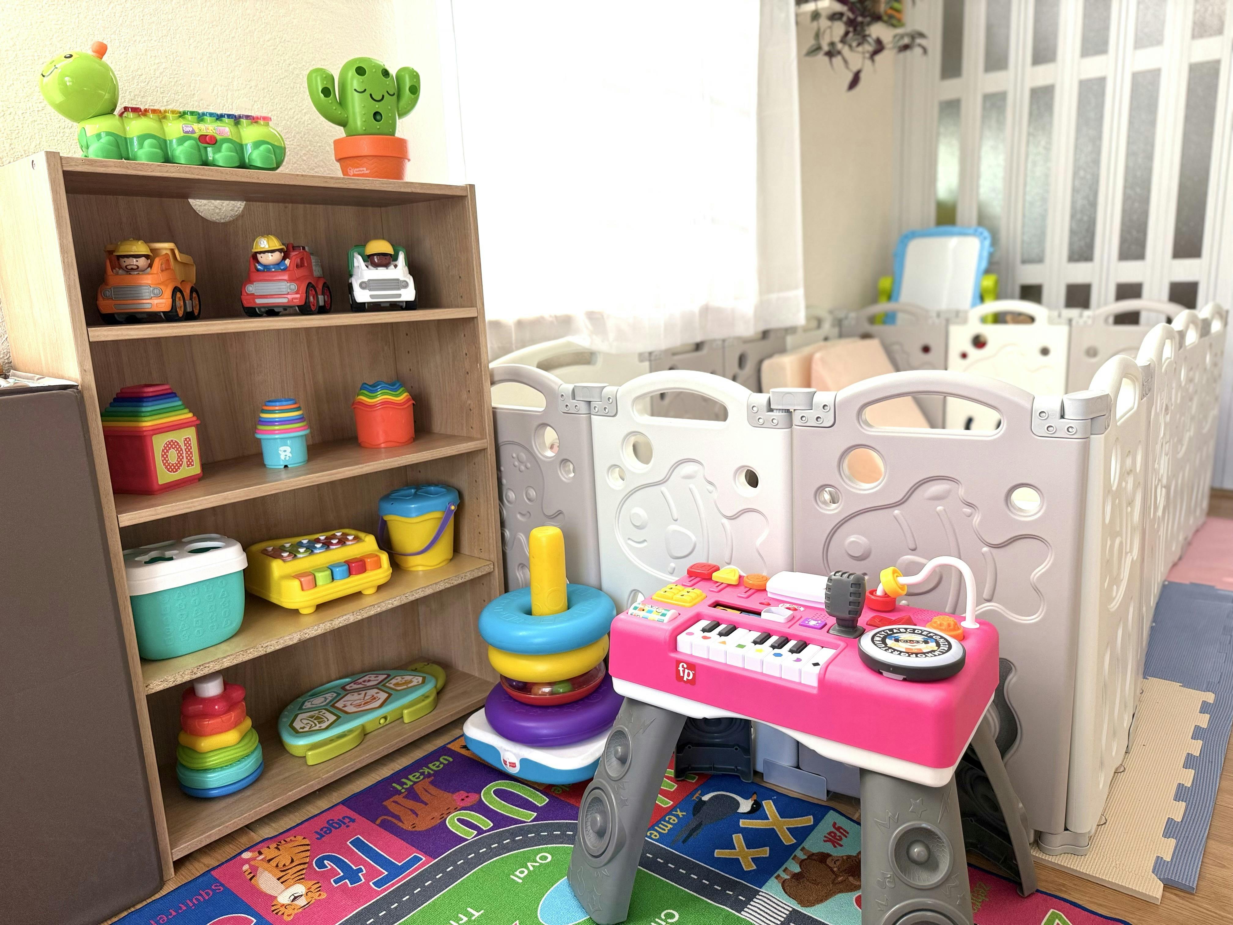 Wooden shelf filled with various colorful children's toys near a playpen
