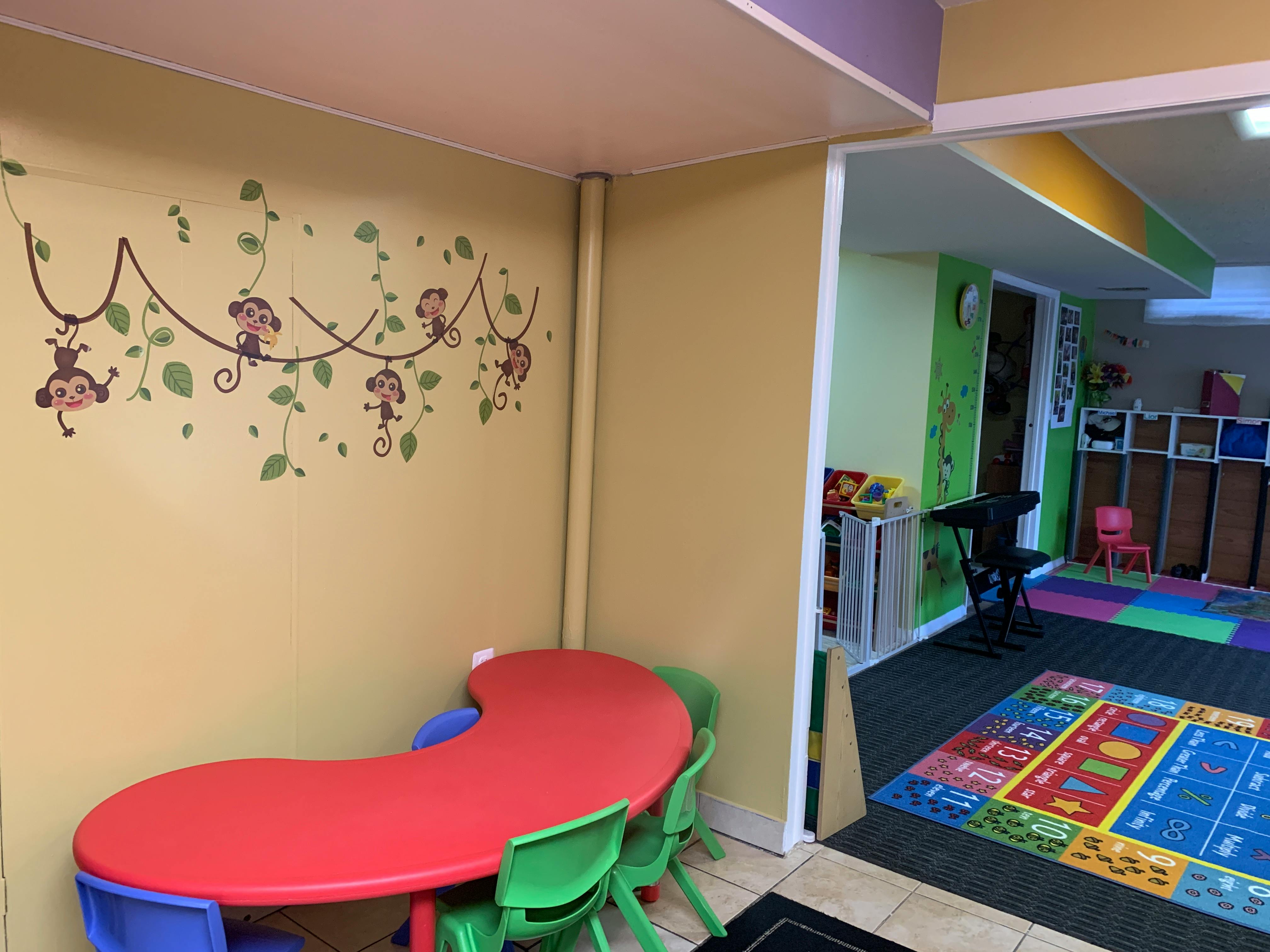 Children's classroom with red table and monkey wall decals