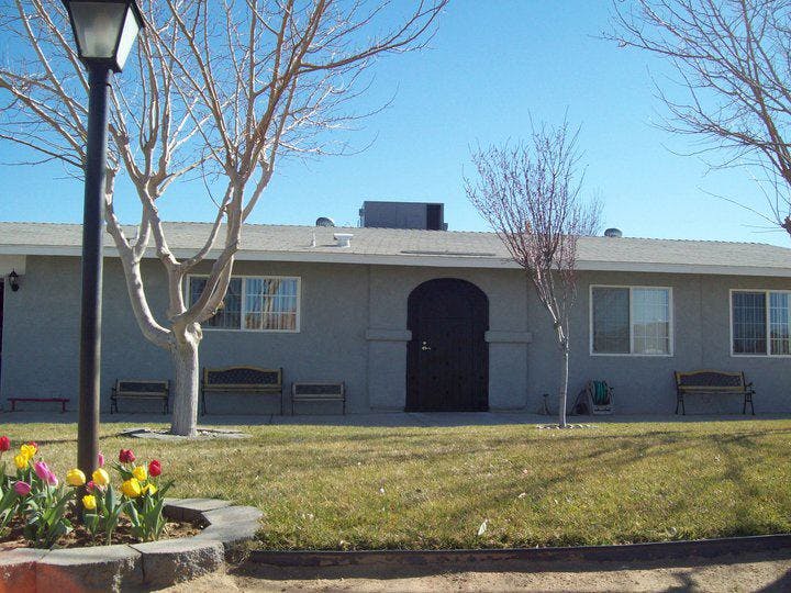 Building exterior with arched doorway, windows, and bare trees