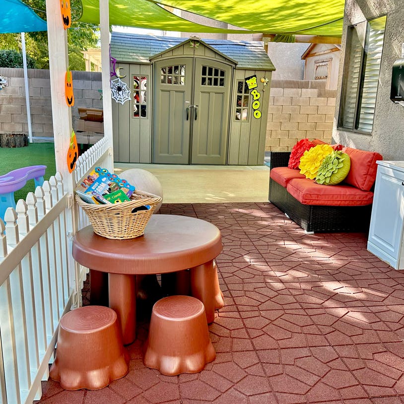 Outdoor patio with a brown children's table and stools, and a small couch