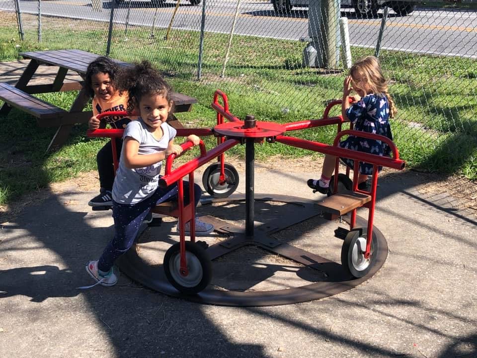 Three children on a red merry-go-round