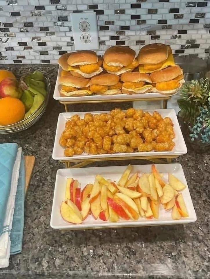 Trays of chicken sliders, tater tots, and apple slices