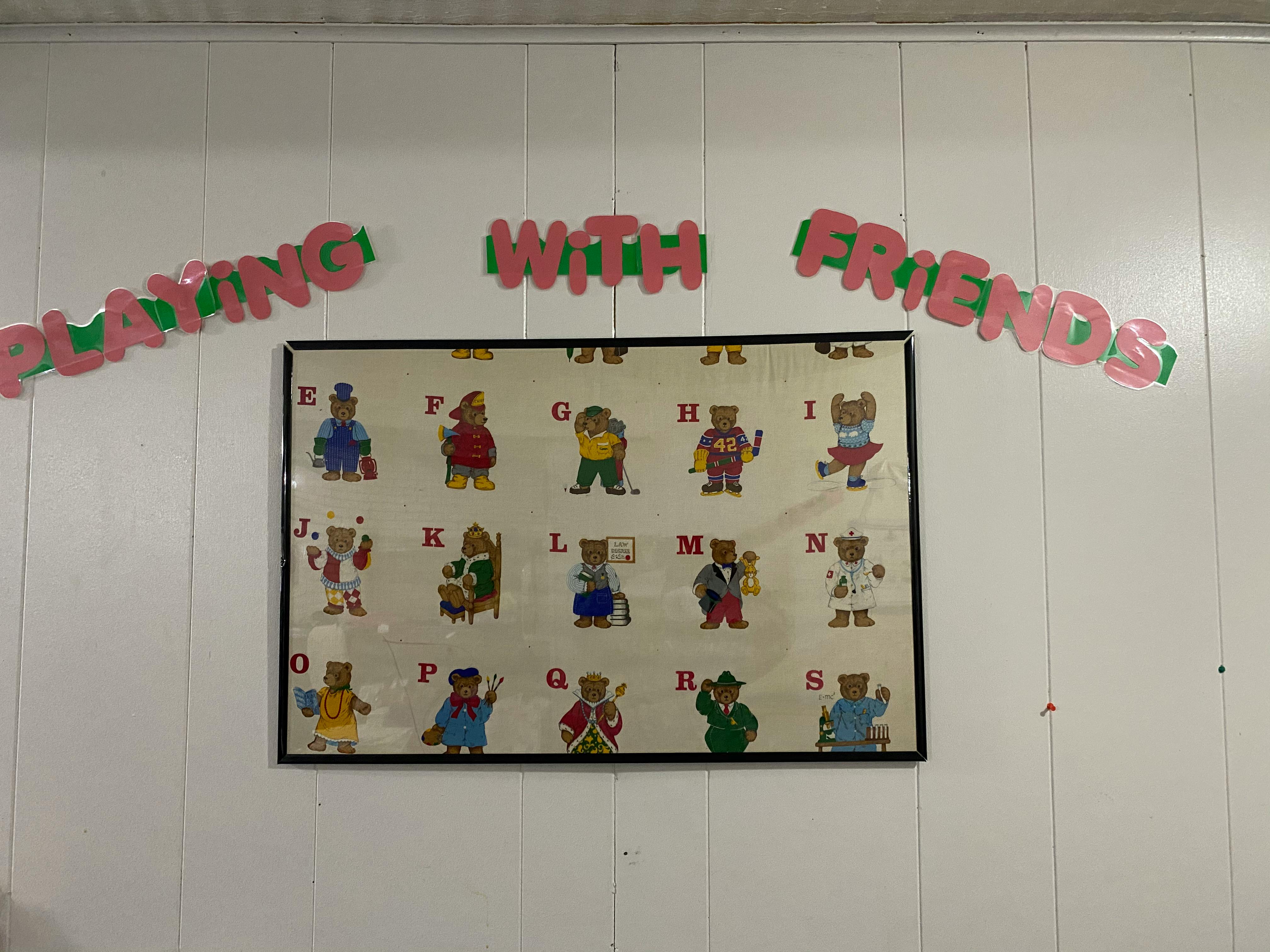 Alphabet chart with cartoon bears and text "Playing with Friends"