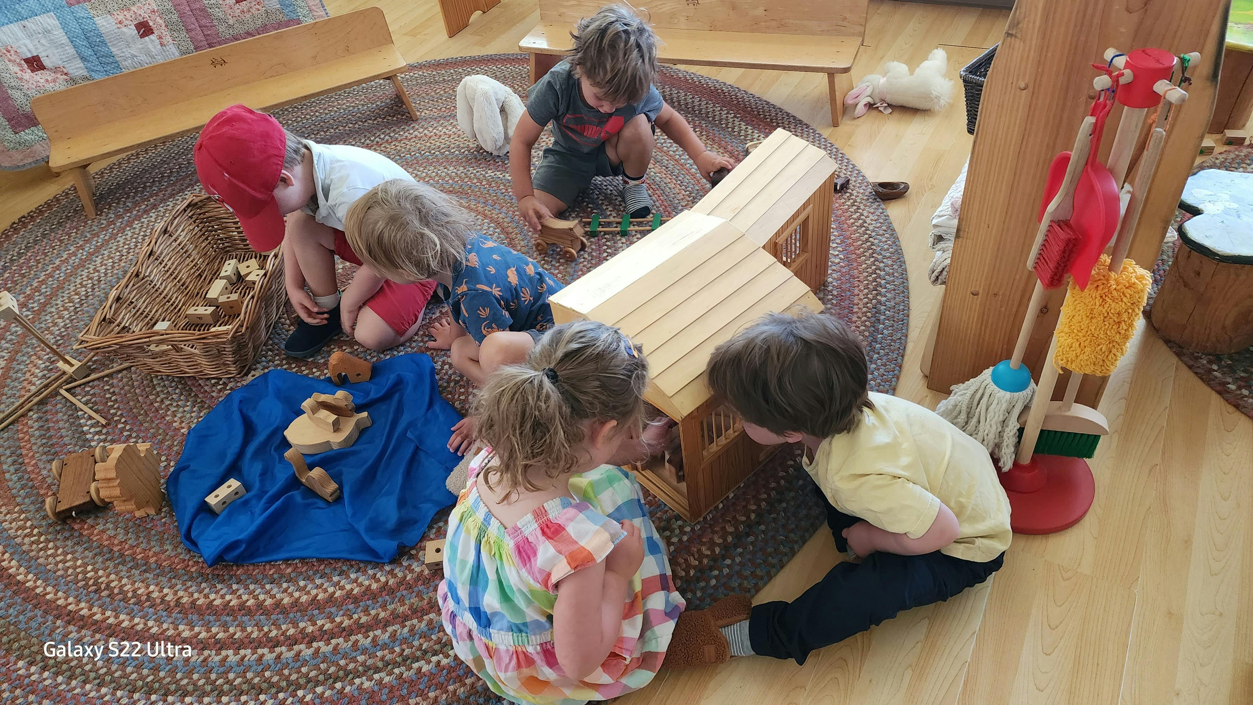 Children playing with wooden blocks and toys on a rug