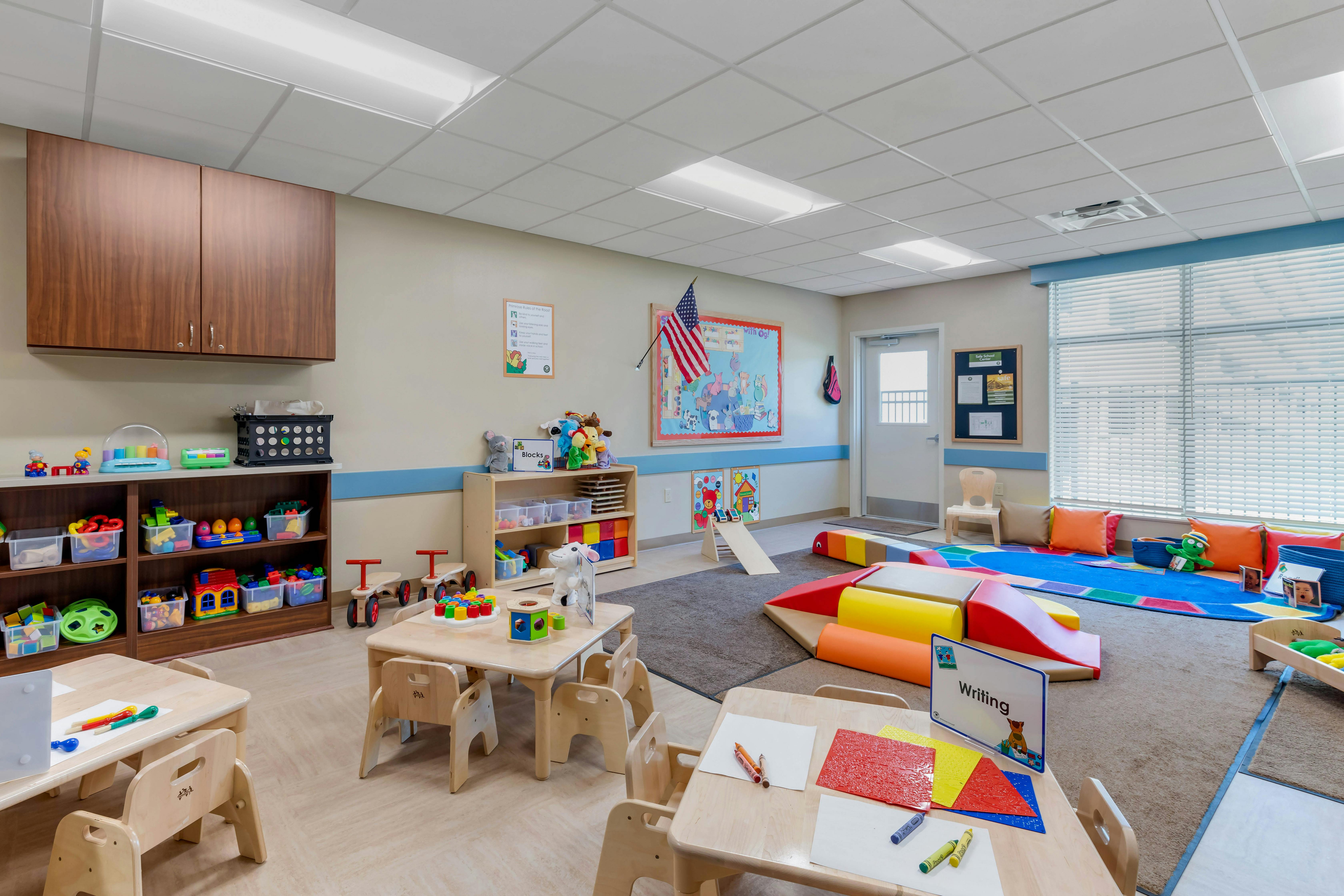 Colorful and organized classroom with toys, tables, and soft play equipment