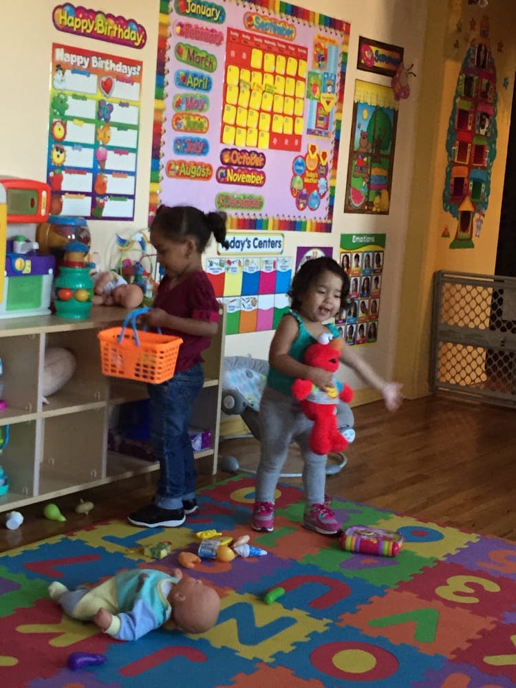 Two children playing with toys in a room with colorful wall decorations